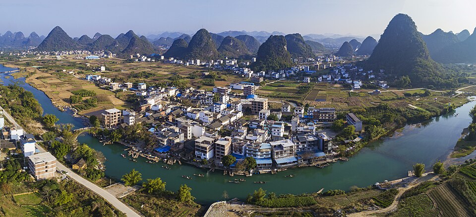 Aerial panoramic view of Yulong Village and surrounding karst hills in Yangshuo County, Guangxi, China.